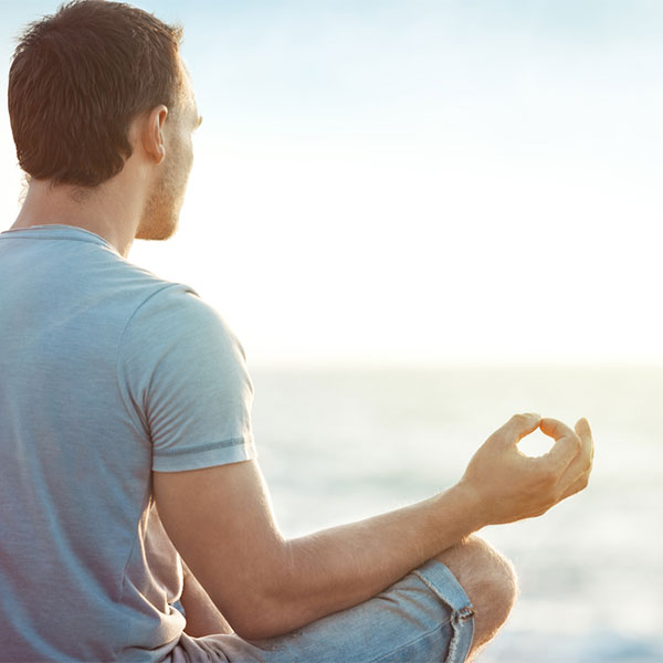 Man meditating on the beach