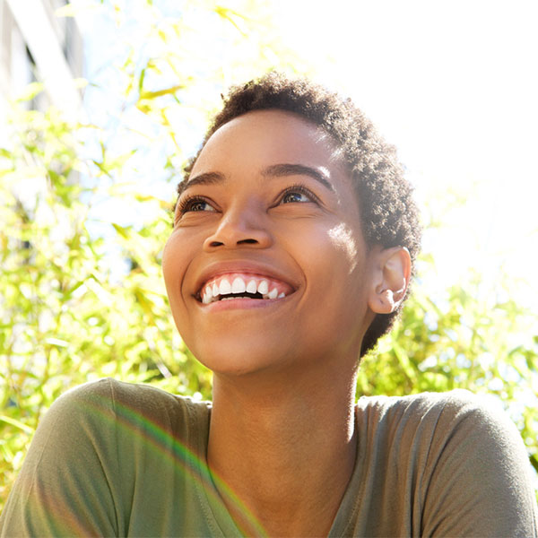 Woman smiling in front of a tree